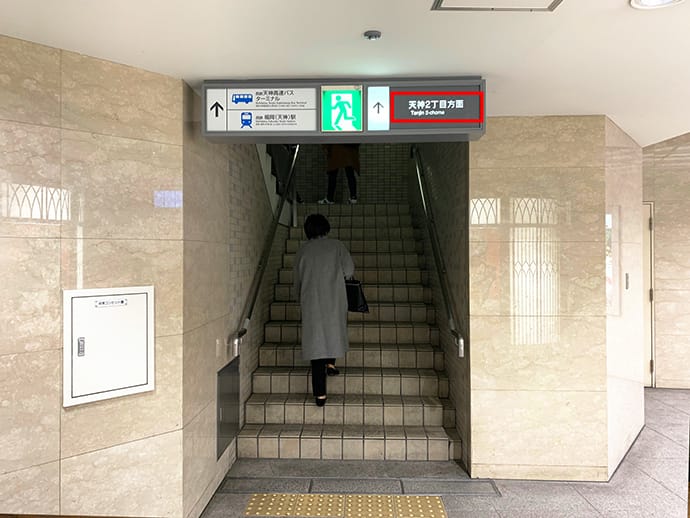 三越入口手前の「天神2丁目方面」の階段をあがり地上へお進みください。【画像】