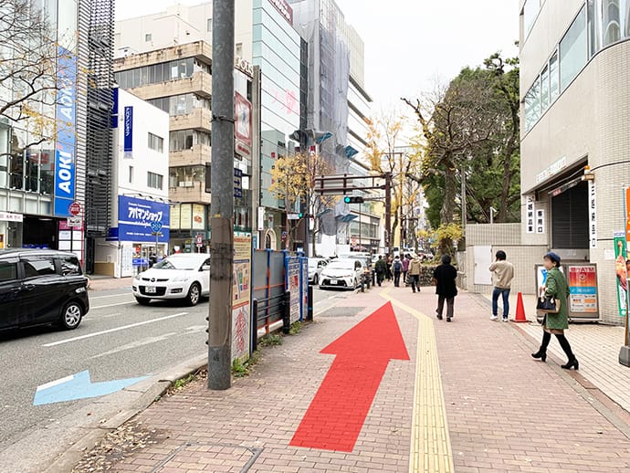 国体道路を改札を背に右へ直進します。警固神社を過ぎ、右手に「ドラッグイレブン」が見えたら交差点を左へ渡ります。【画像】