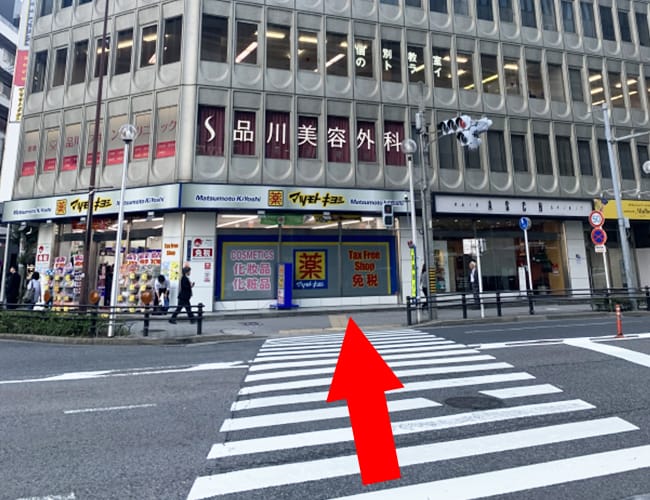 「中央郵便局北」交差点の右手側の信号を渡ってください。1階にマツモトキヨシがあります。【画像】